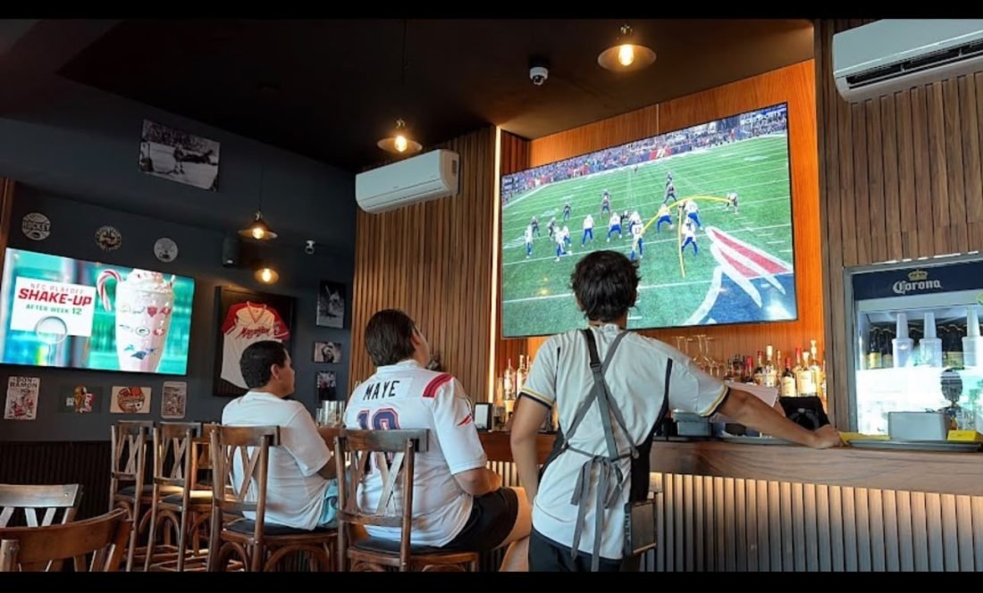 Patrons at the bar of Guicho's Sports Bar in Nuevo Vallarta watching an NFL game on a large wall-mounted screen