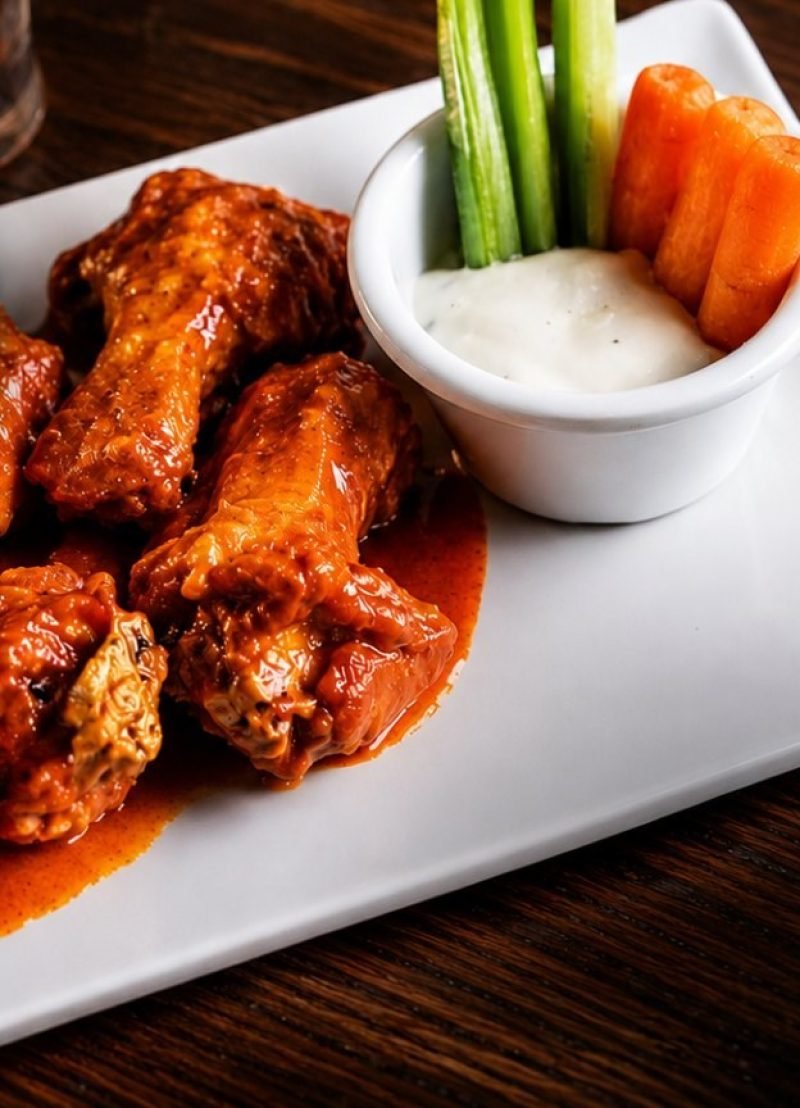 Plate of buffalo wings with celery and ranch dressing at Guicho's Sports Bar in Nuevo Vallarta